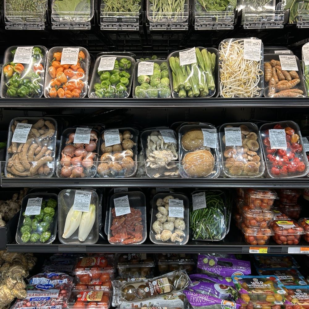 Packaged produce with visible price tags and labels on organized supermarket shelves